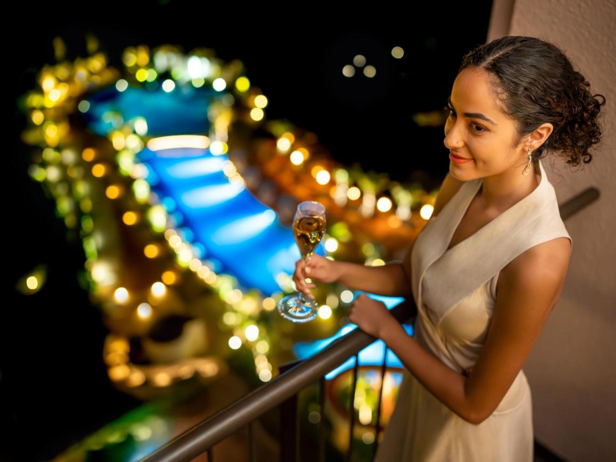 Oriental Hotel Okinawa Resort & Spa Nago Dış mekan fotoğraf A woman holding a glass of champagne